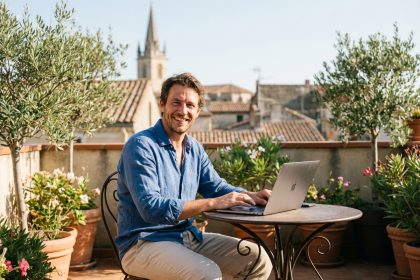 Homme souriant travaillant sur un ordinateur &agrave; B&eacute;ziers